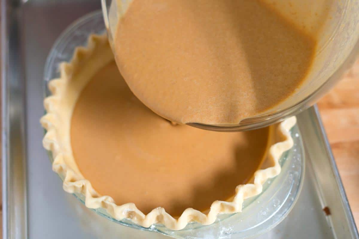 How to Make Pumpkin Pie: Pouring the filling into our crust.