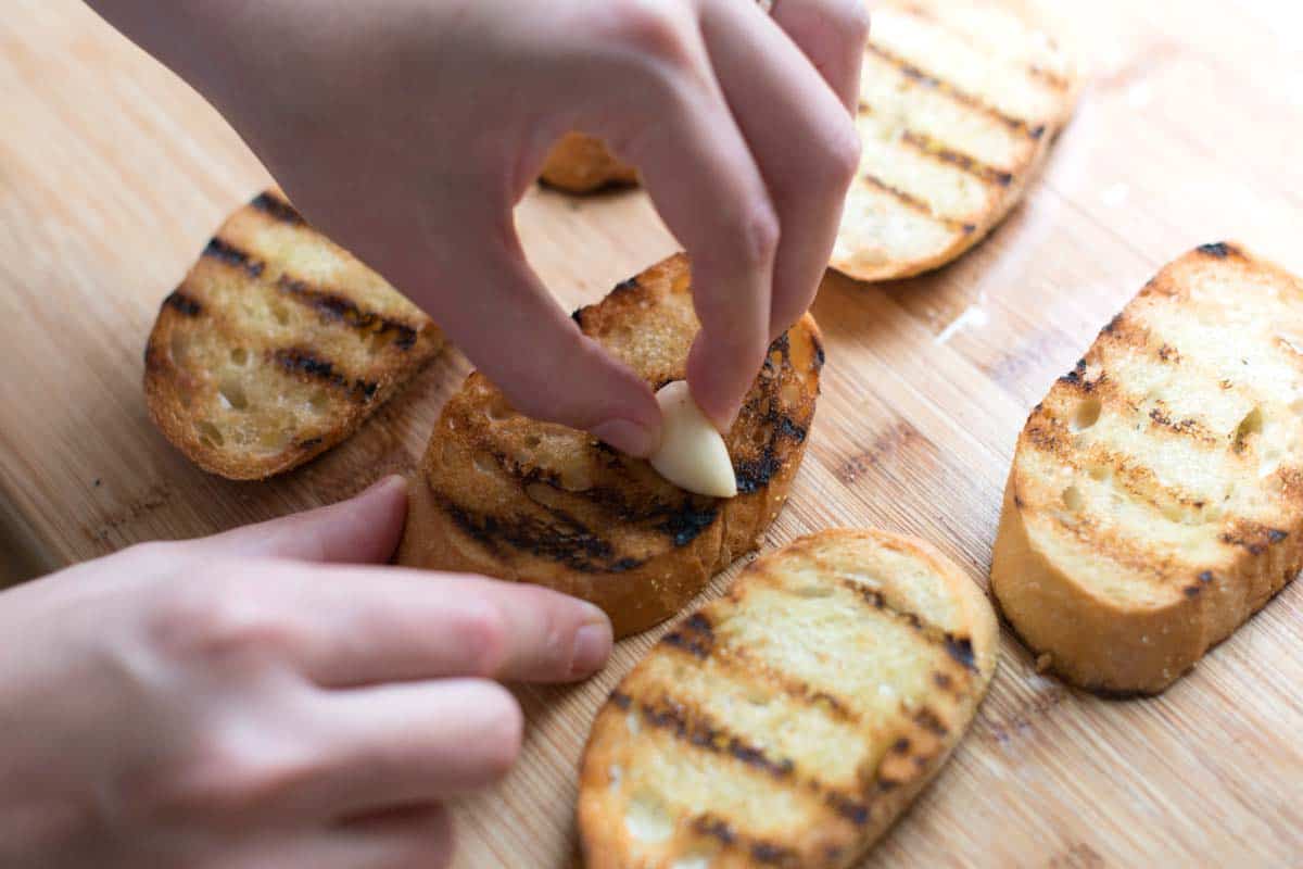 Rubbing toasted bread with a fresh garlic clove for bruschetta