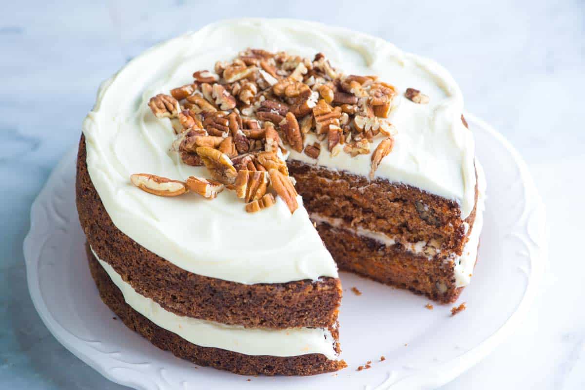 The best homemade carrot cake with cream cheese frosting showing a slice cut out