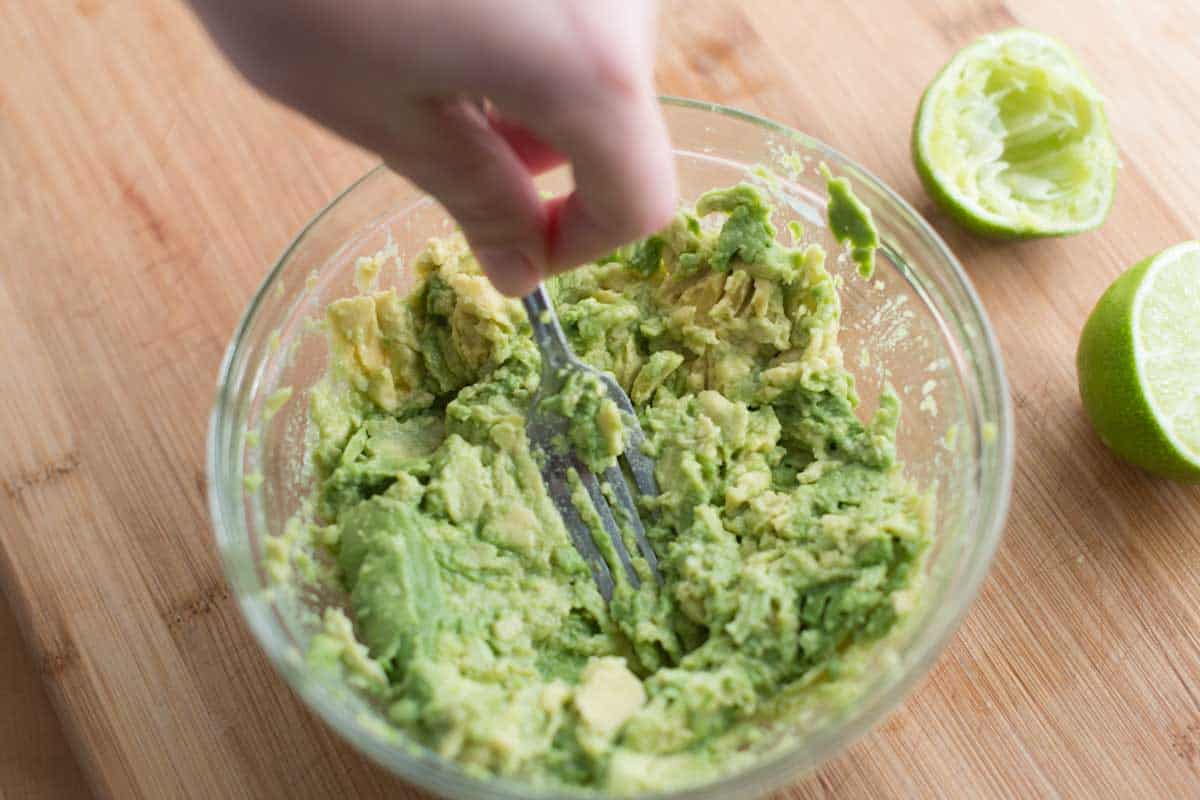 Mashing avocado for guacamole with a fork