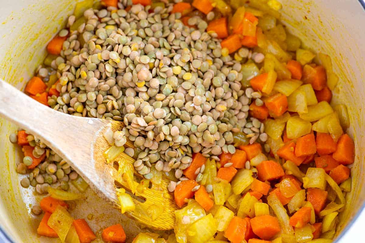 Uncooked lentils with carrots, onions and turmeric for Homemade Lentil Soup