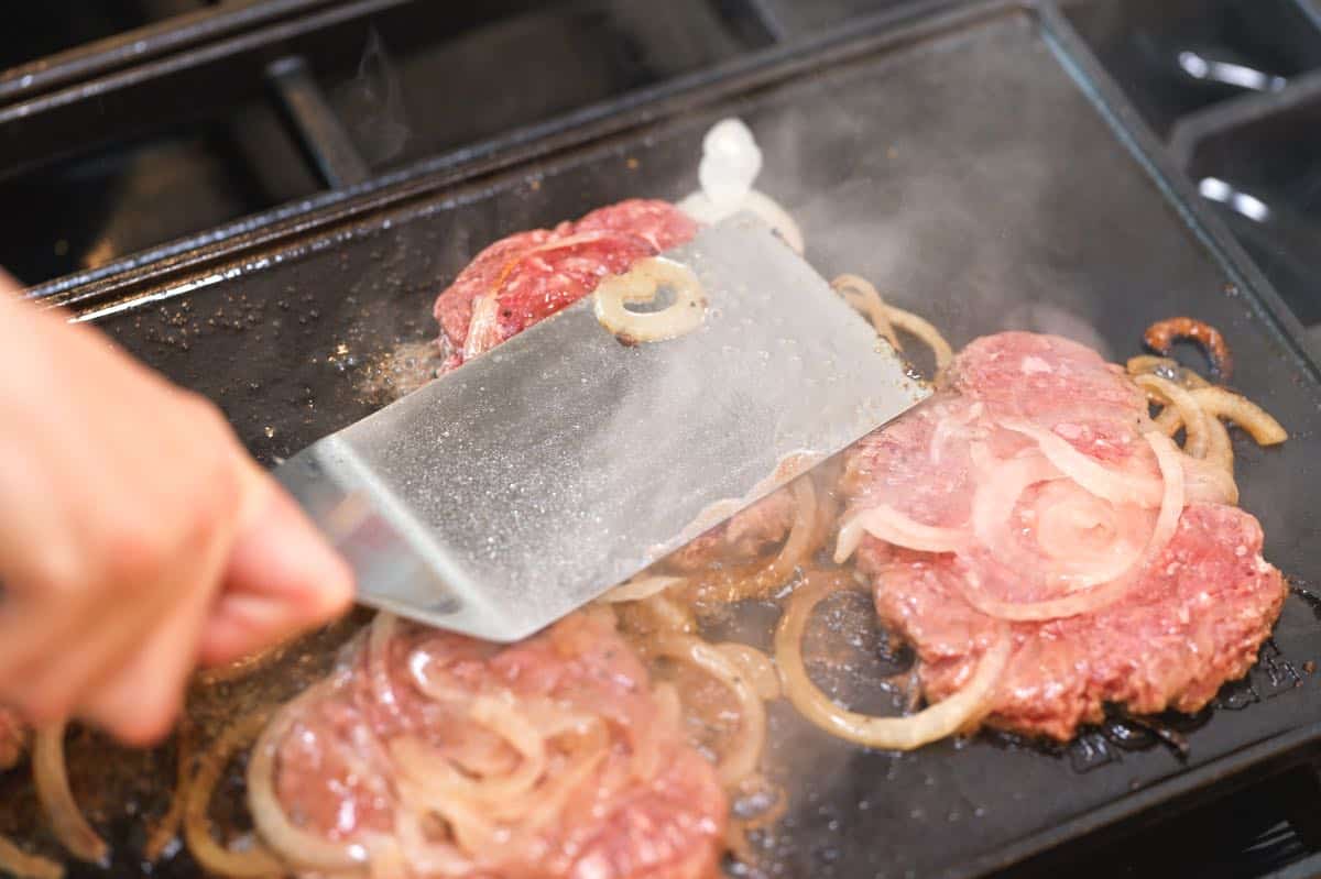 How to make Smash Burgers: Pressing out ground beef into smash burgers using a stiff spatula.