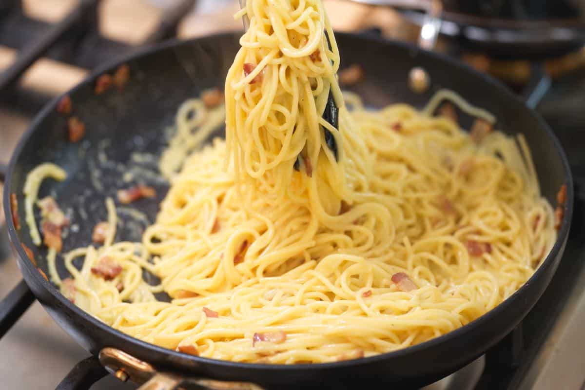 How to Make Carbonara: Tossing the egg and cheese mixture with pasta in a skillet