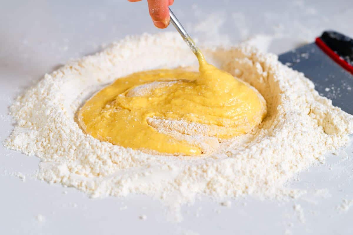 How to make pasta: Mix flour into egg mixture to make dough