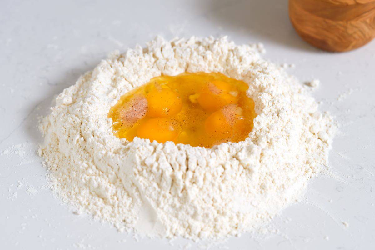 How to Make Pasta: Flour with eggs, salt, and olive oil in a well in the middle